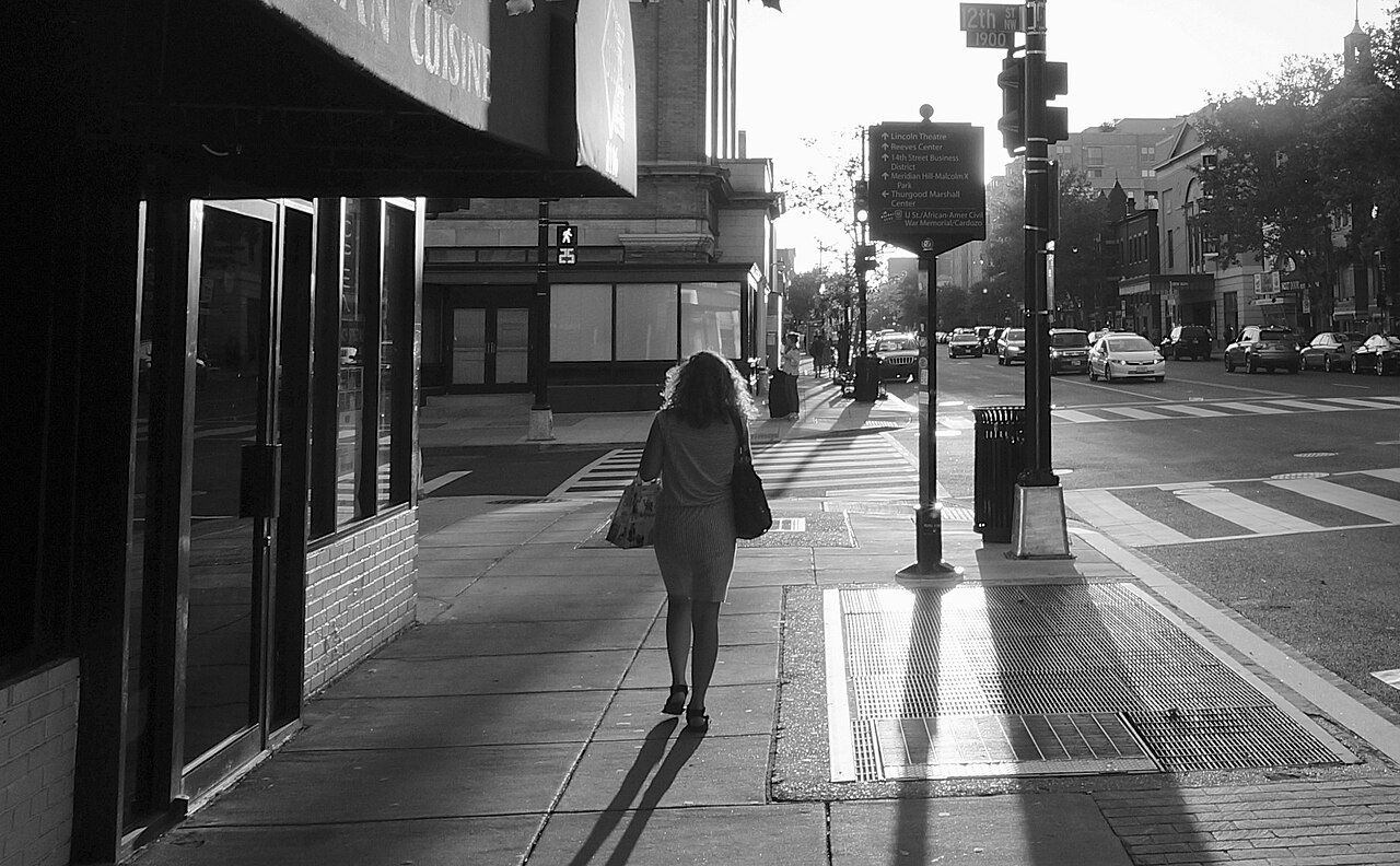 People walking along U Street in Washington DC at sunset near bars and music venues