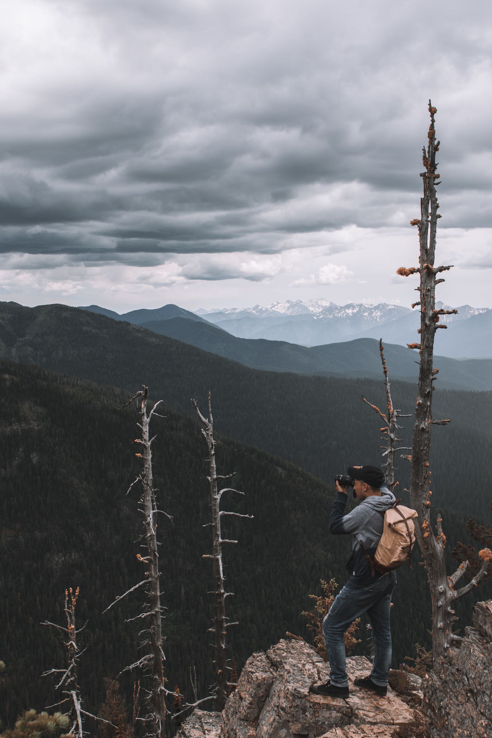 Hiker on a mountain summit filming the view, showing how an action camera captures hiking adventures