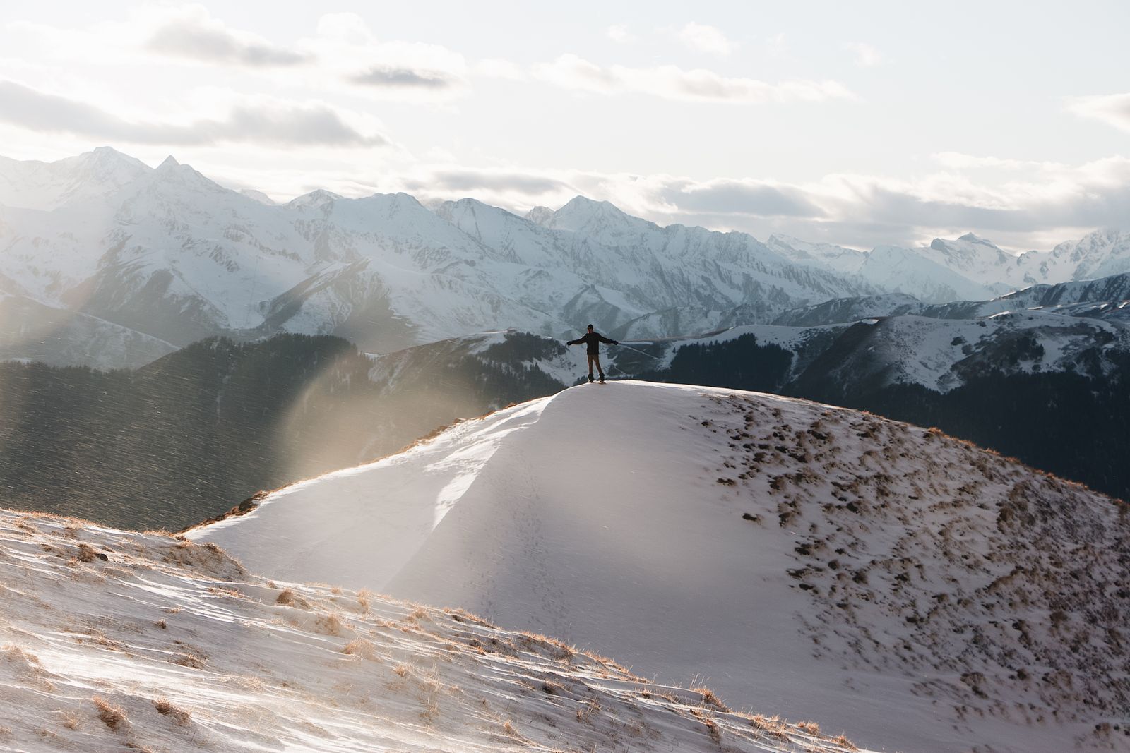 Climber standing on a snow-covered mountain summit