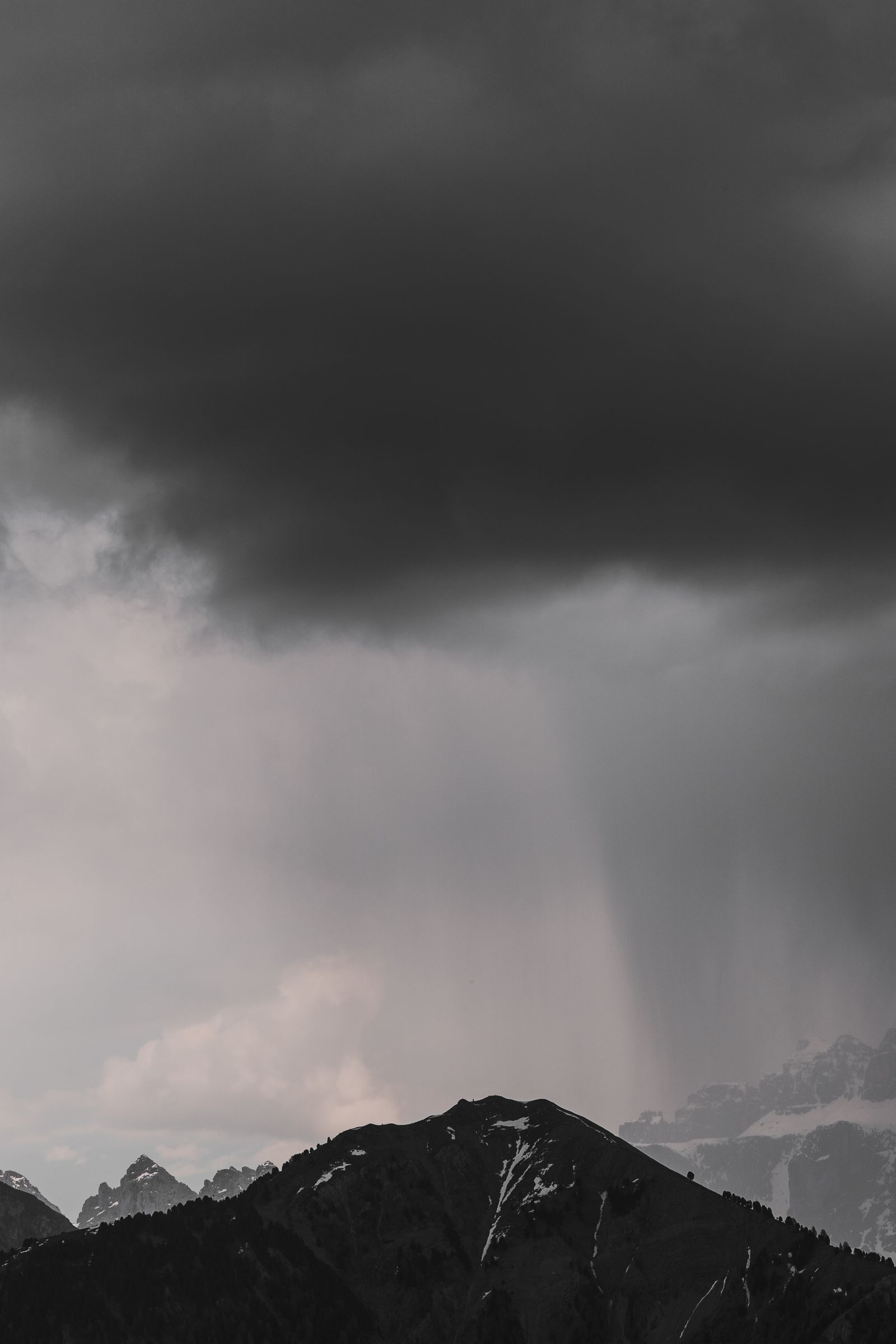 Storm clouds building over a mountain range, the kind of weather an emergency NOAA radio warns hikers about