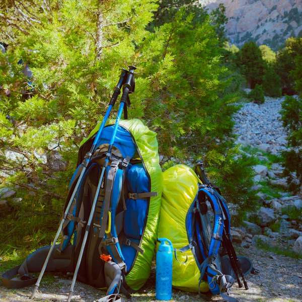 Black and blue hiking backpacks resting on rocky mountain ground