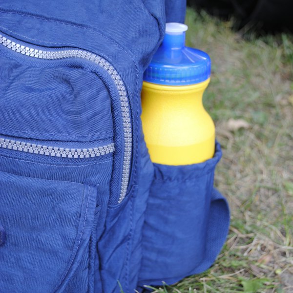 Blue lightweight hiking backpack with a water bottle in the side pocket