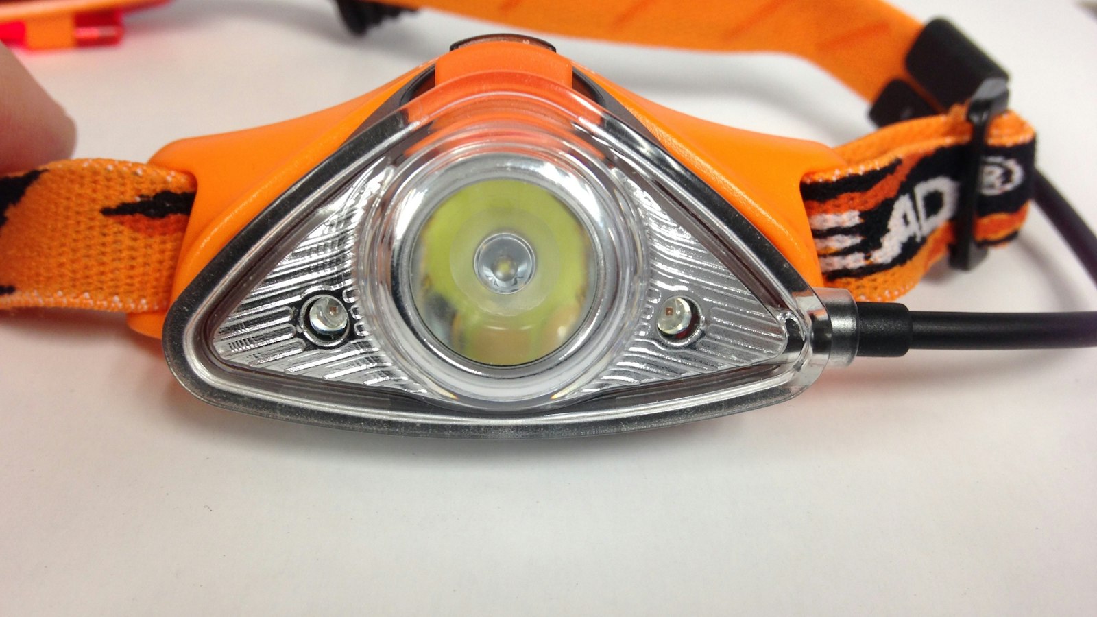 Close-up of a compact LED headlamp with an adjustable strap