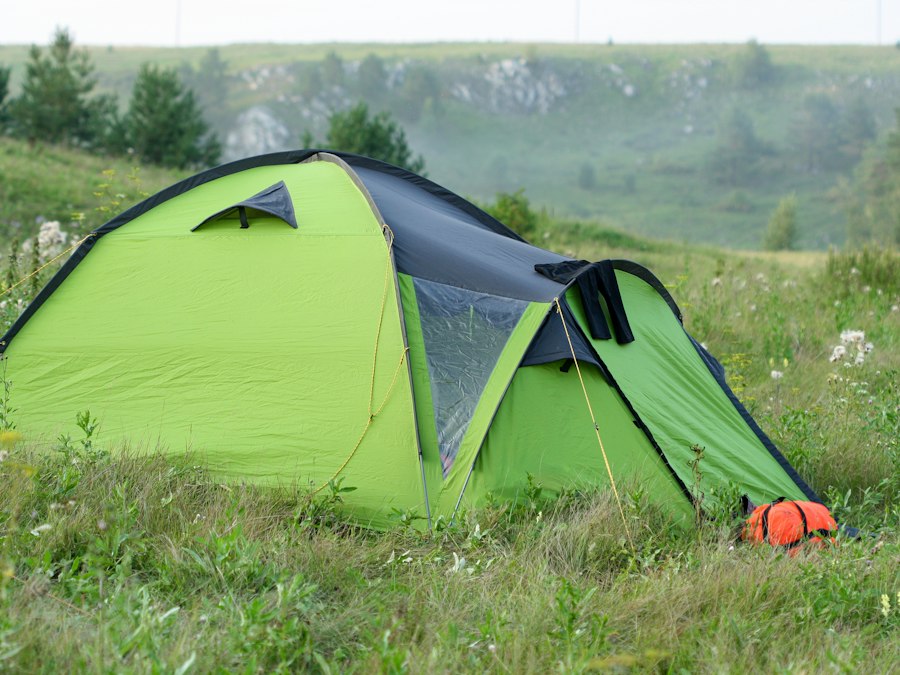 Small dome backpacking tent pitched on grass