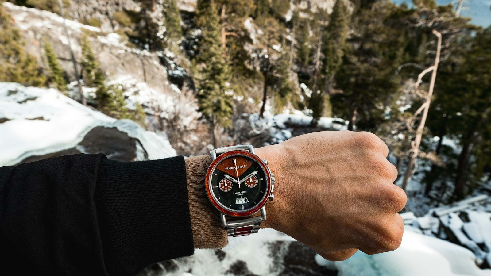 Hiker wearing a watch on top of a mountain