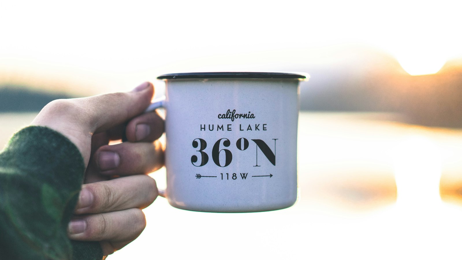 Single-wall metal camping cup outdoors, similar in style to a lightweight backpacking mug