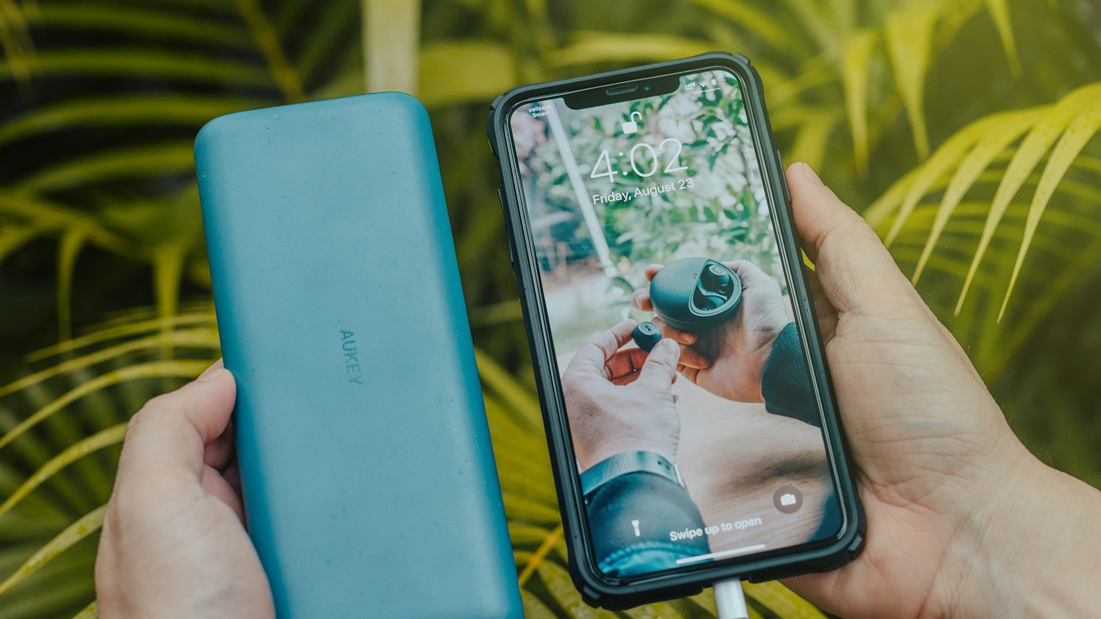 Smartphone next to a compact green power bank, close-up