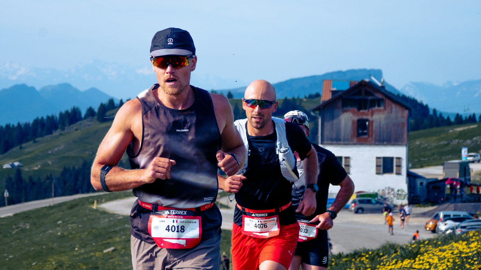 Trail runners climbing a sunny mountain path near Annecy, France
