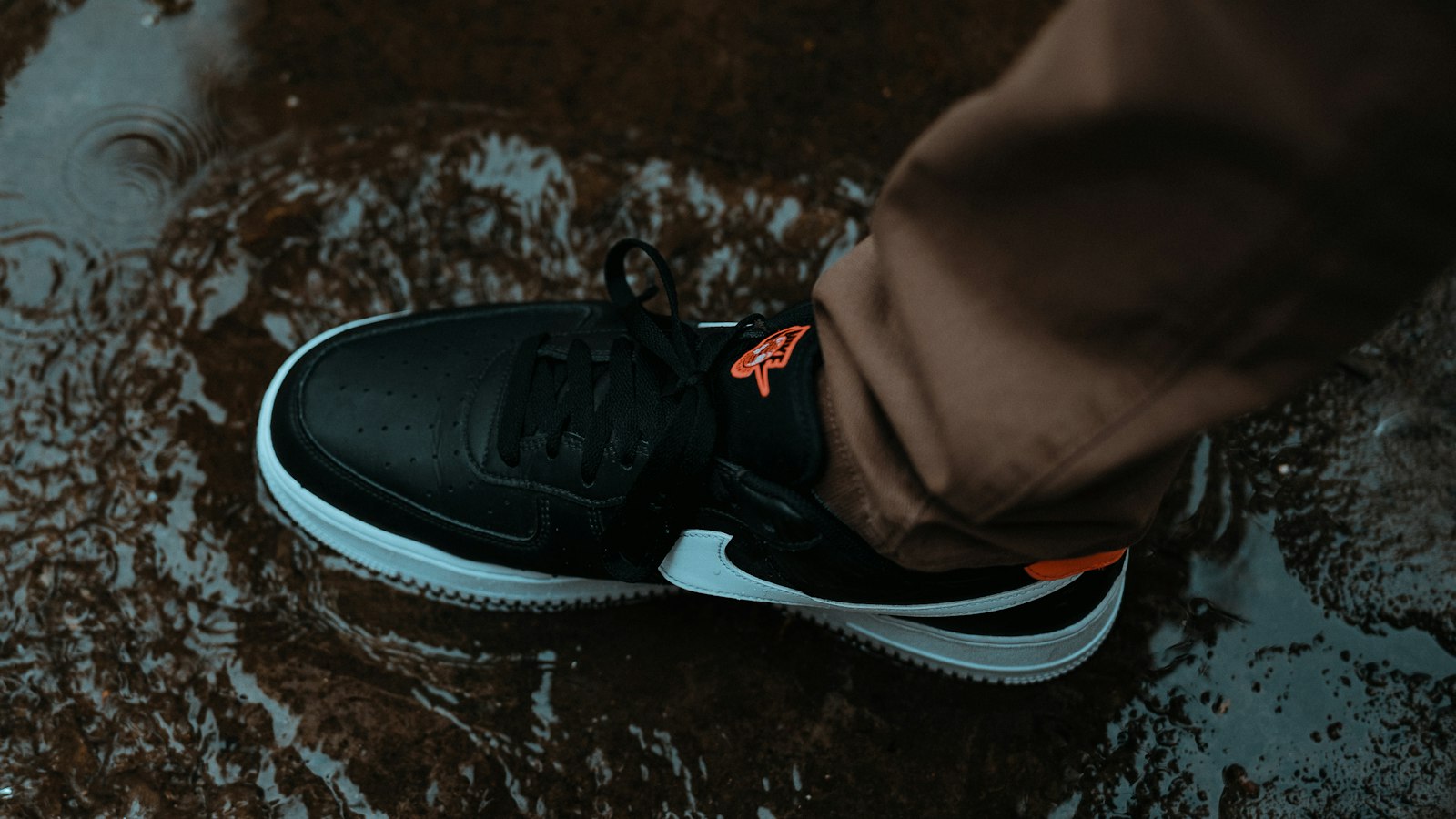 Traveler standing in a rain puddle wearing black sneakers