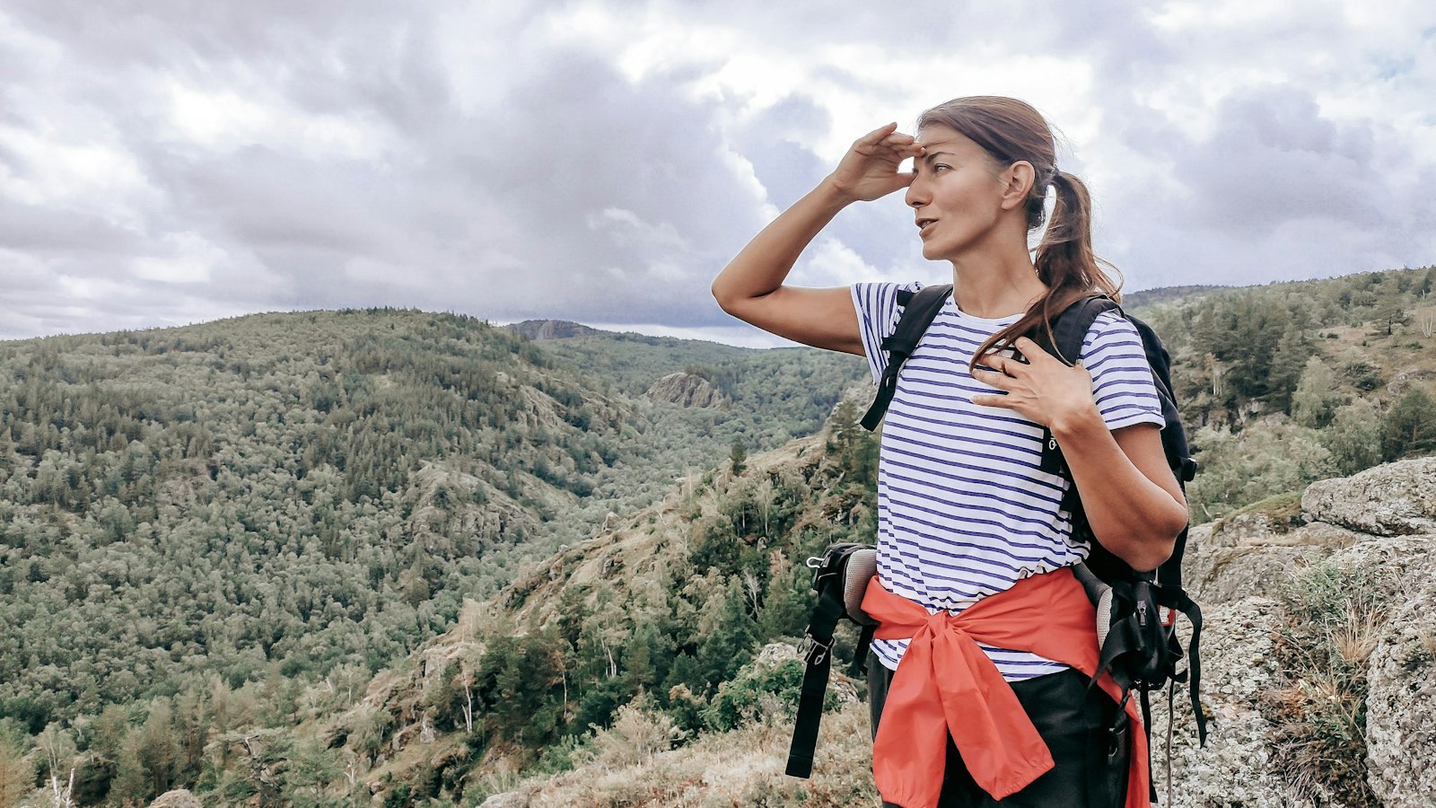 Backpacker with a lightweight pack standing on a mountain summit