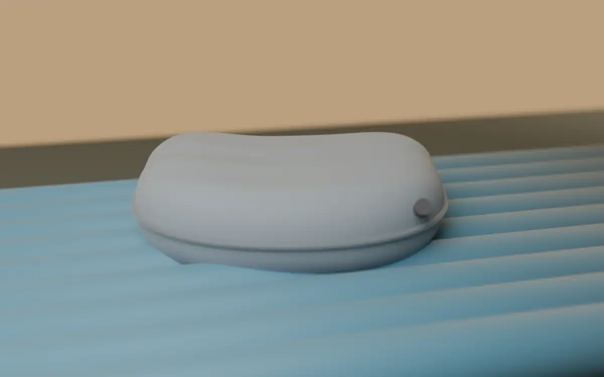 Light gray ultralight inflatable camping pillow with curved shape on a blue sleeping pad