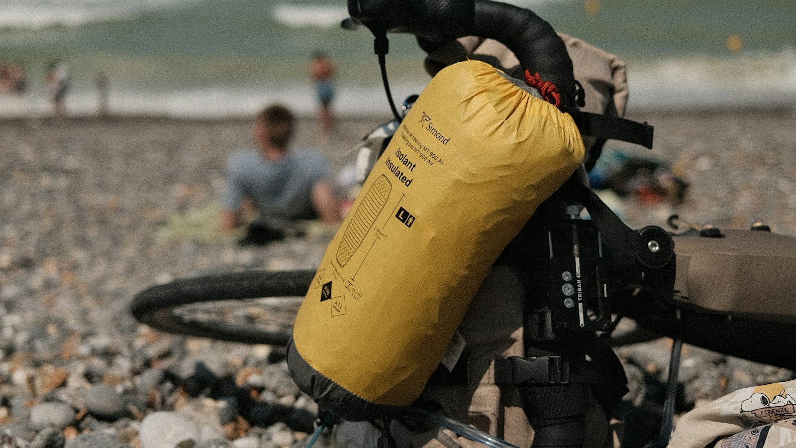 Outdoor gear packed for a wet coastal trip on a rocky beach by the ocean