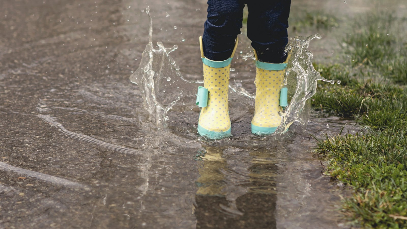 Person wearing yellow rain boots on a wet street
