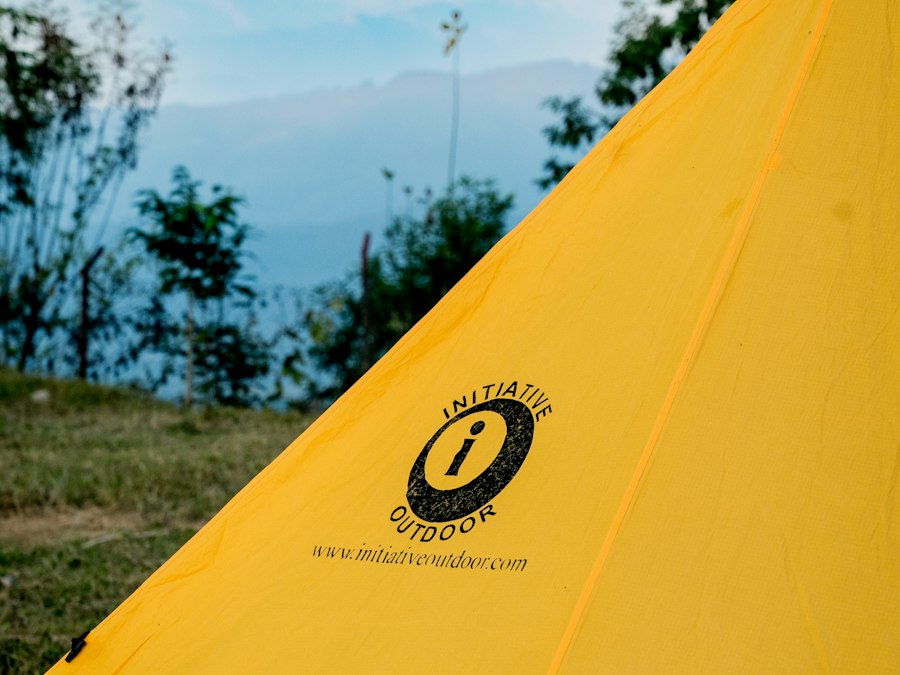Yellow lightweight tent pitched on a green field